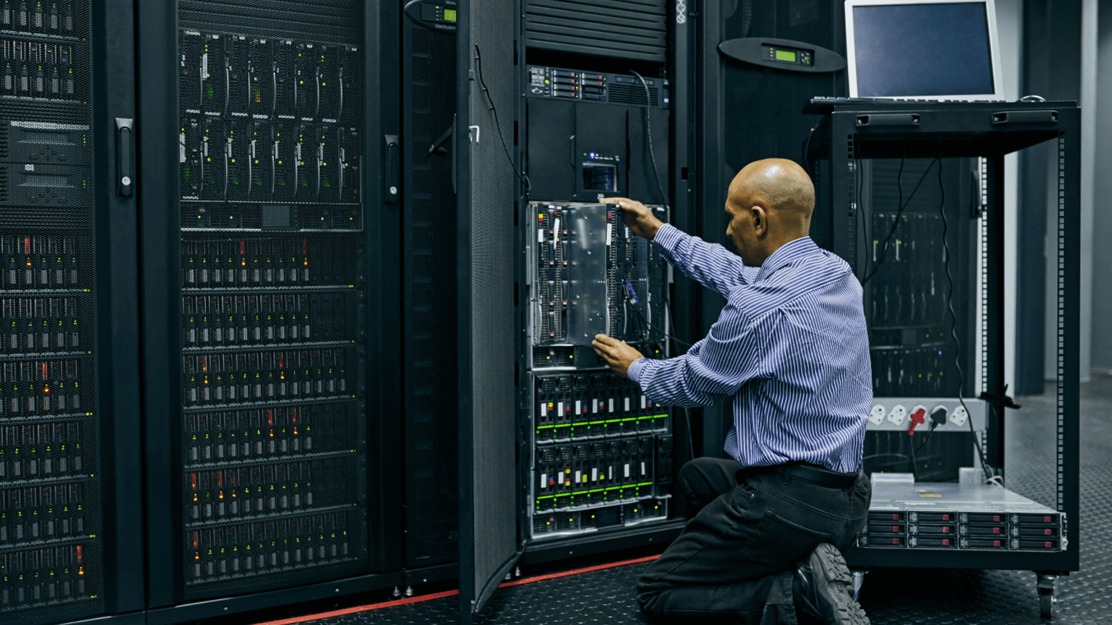 Enterprise server room technician performing maintenance on mission-critical compute infrastructure